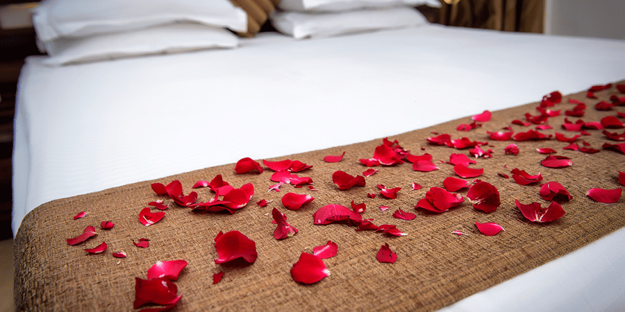 A close up view of the bed decorated with flower petals in Regent Room.