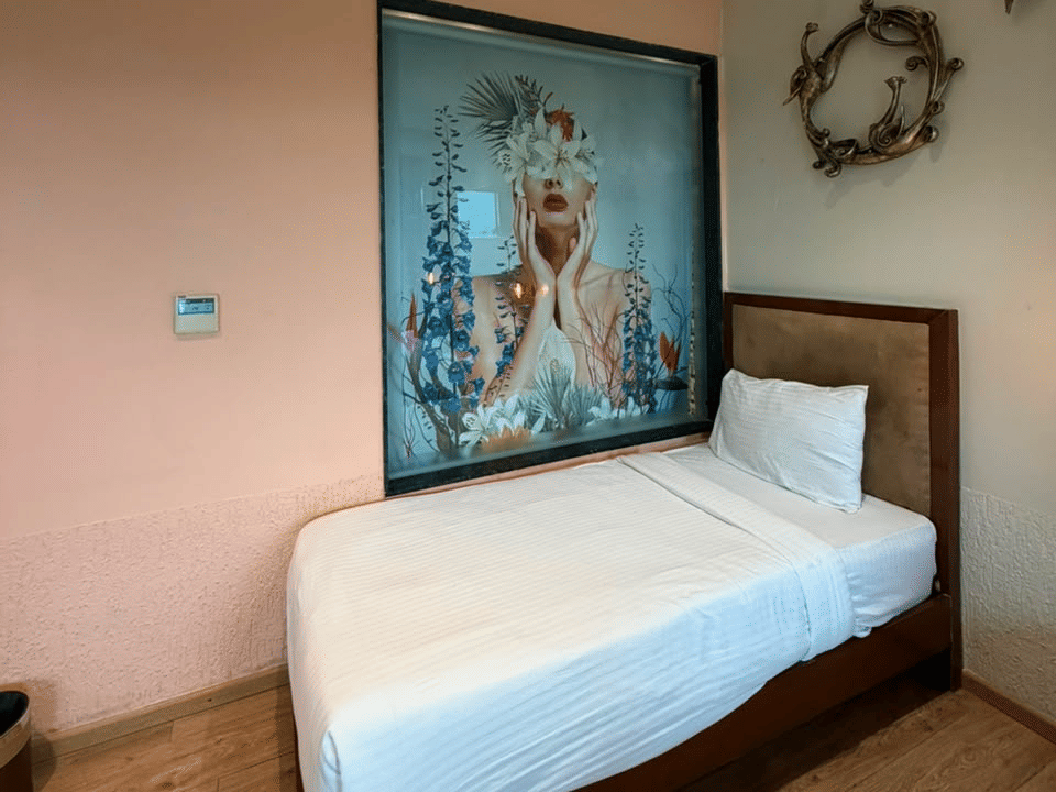 Family Room, Single bed beneath framed artwork