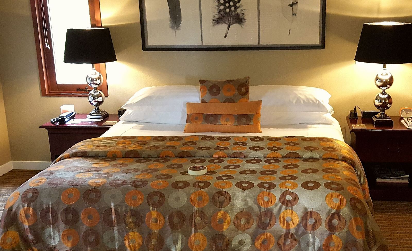 A beautifully designed bed with patterned bedding and warm tones - Brewery Gulch Inn & Spa