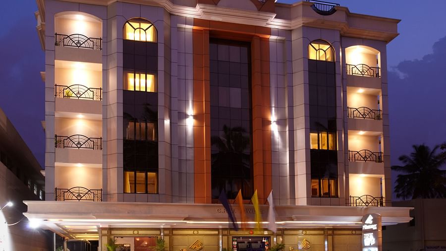Grand facade of The President Hotel Jayanagar, Bangalore with striking red accents and a majestic entrance, showcasing a blend of traditional and contemporary architecture
