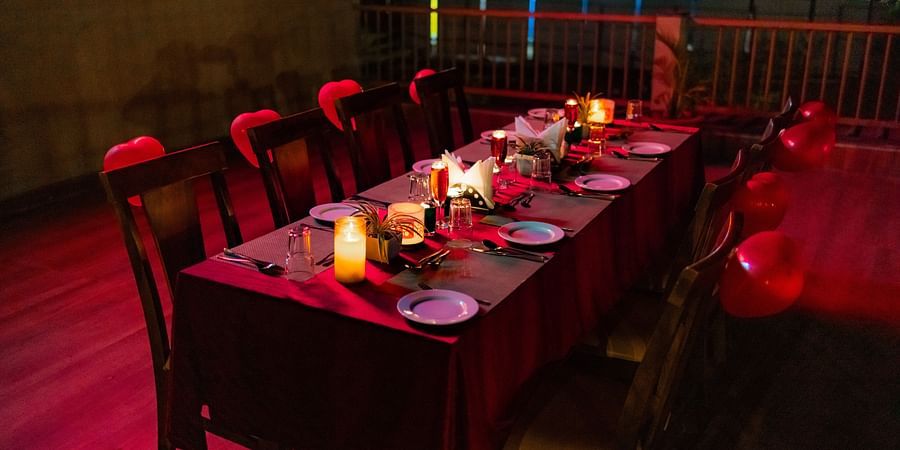 Rooftop dining table set for a group meal with tableware and festive decorations - Mastiff Grand La Villae Resort, Lonavala