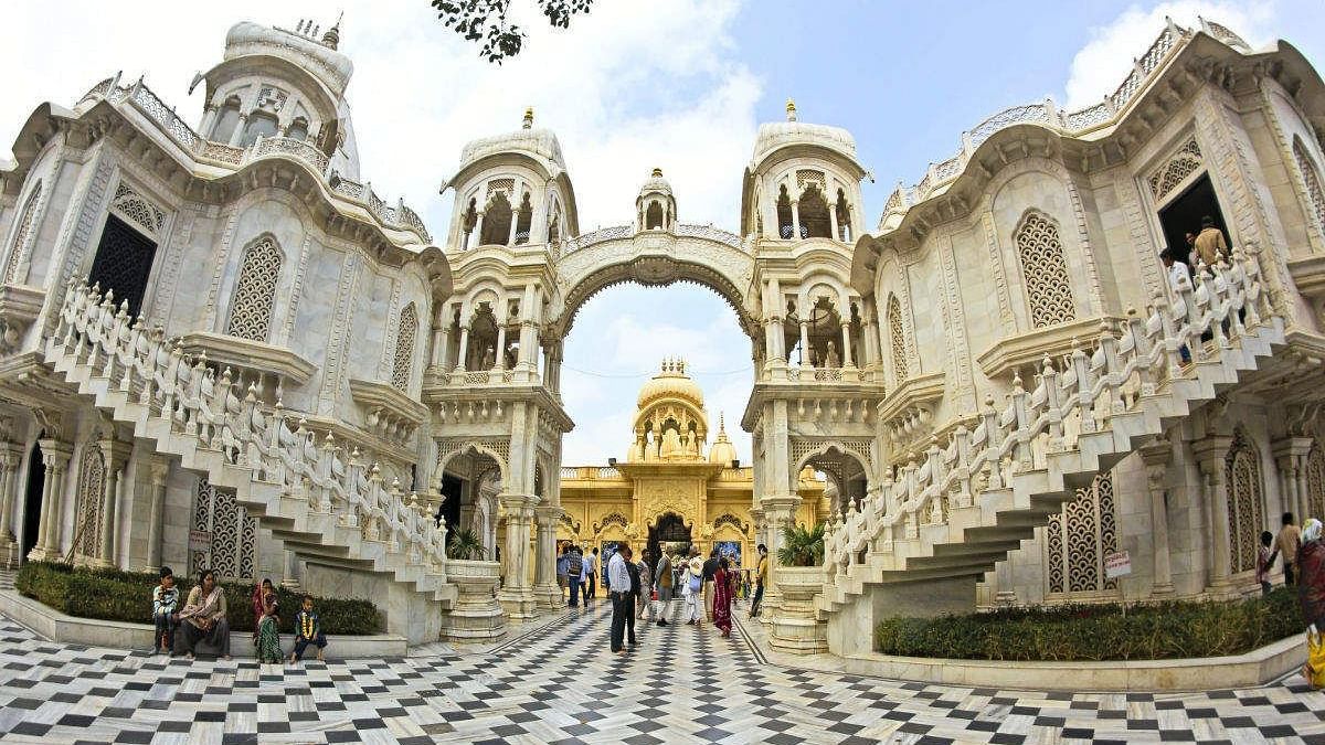 An image of ISCON Temple with magnificent architecture and flooring and devotees are roaming around  