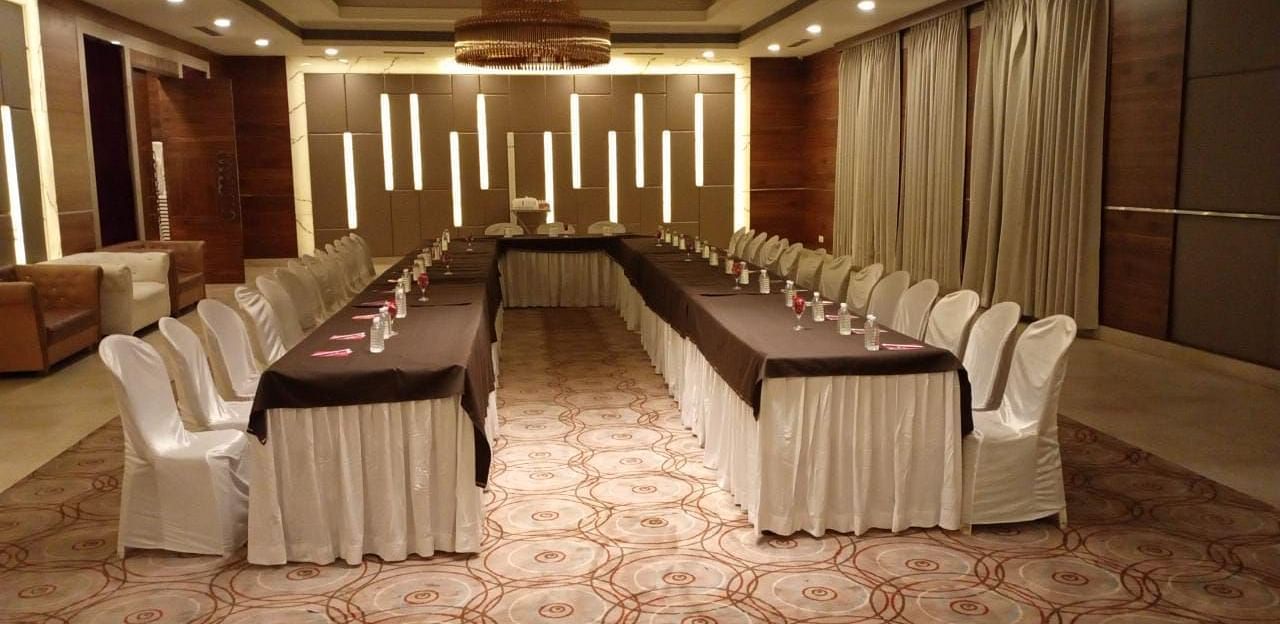 A formal meeting room at Rang Lords Inn, with a long conference table and arranged chairs, ready for business meetings or presentations 