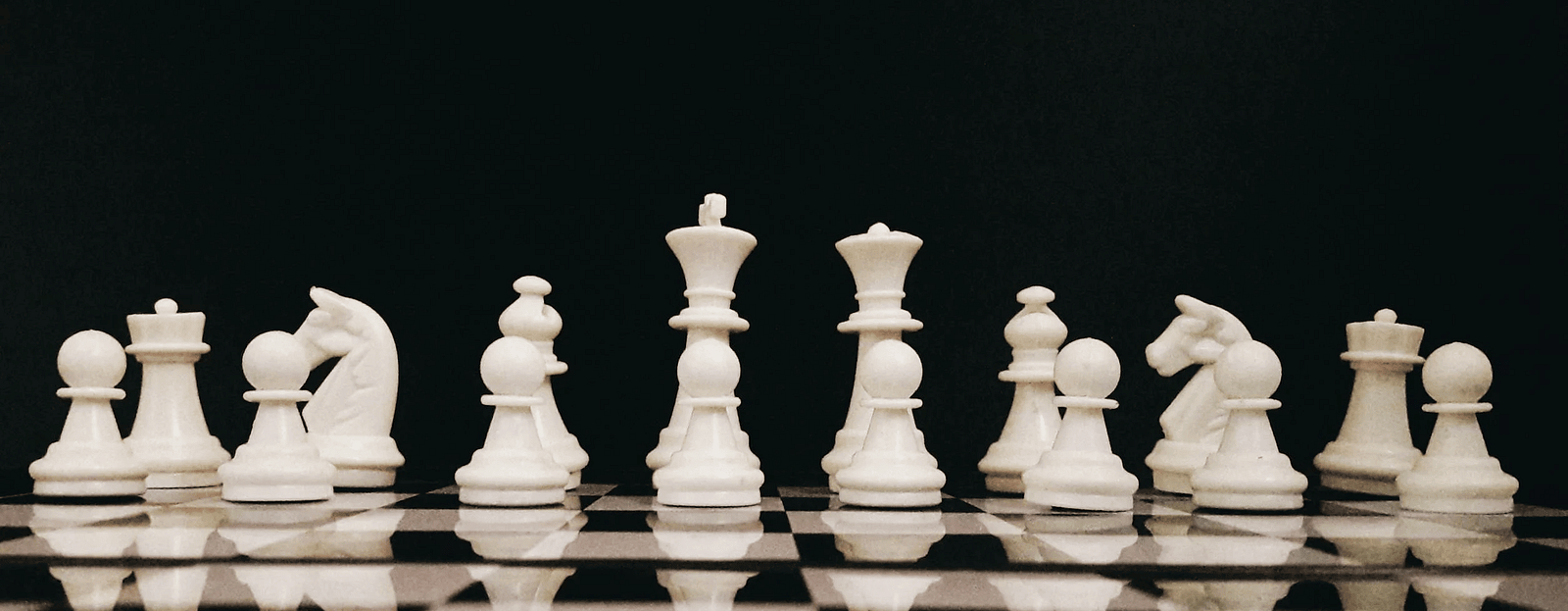 A close up of a wooden chess board featuring intricately carved pieces in the middle of an ongoing game