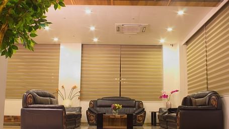 An inviting hotel entrance or lobby at Lords Inn Porbandar, with modern seating and natural light filtering through blinds.