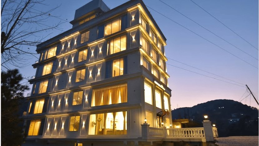 Exterior view of Claret Inn at dusk, illuminated with warm lights and showcasing its modern multi-storey architecture.