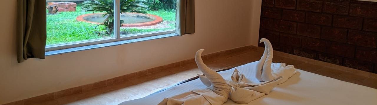  A bedroom with a scenic garden view through a large window at The Conservancy Bungalow.