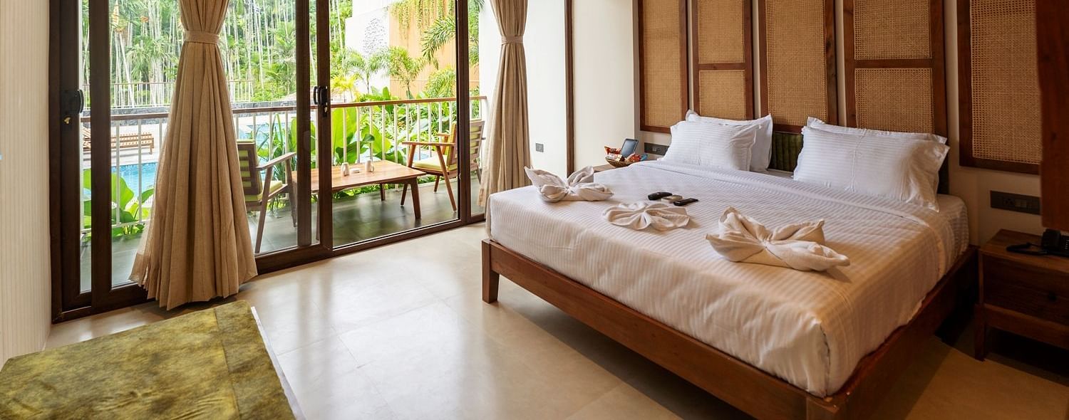 Well-lit bedroom featuring ample natural light, a comfortable bed, and scenic views of greenery outside - Sea Hills Resort, Swaraj Dweep (Havelock)