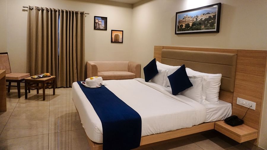 Side view of a room with a bed and a photo frame above the bed at Clarks Inn Express, Udaipur.