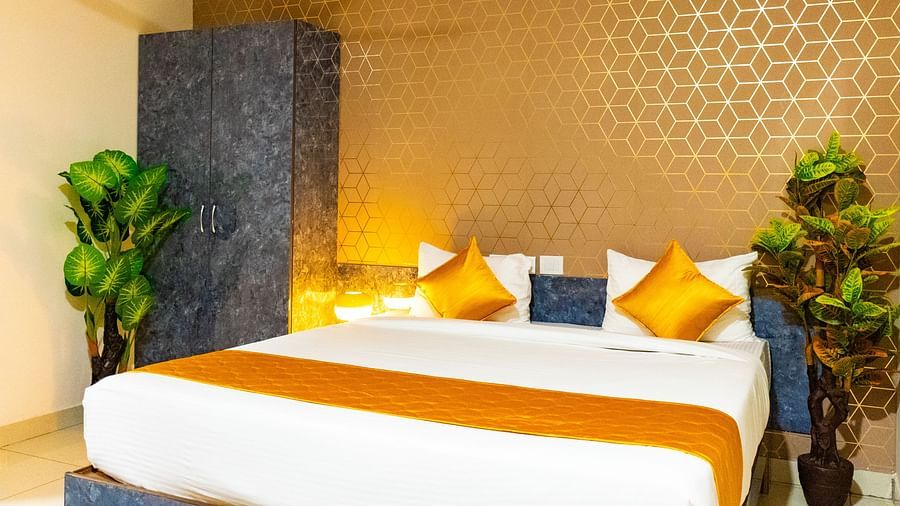 An image of bedroom that has a king size bed and a wardrobe table next to it - Hotel Aerotel, Hyderabad - A Unit of Comfort Hometel