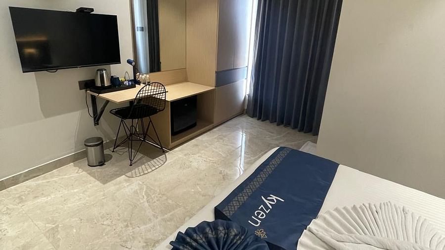 Suite with stylish furniture, including a sofa and writing desk at Hotel Kyzen HiTech City – Your Zenly Stay