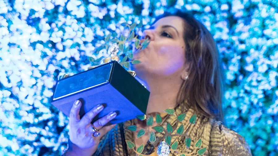 Kiran Bawa of IOSIS Spa & Wellness, holding the accolades during an event.
