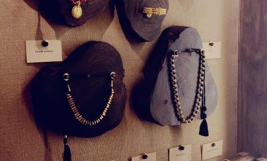 Close-up of necklaces displayed on dark stands.
