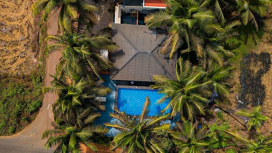 An aerial view looking down at Kssemya with a swimming pool nestled amongst green vegetation and pathways.