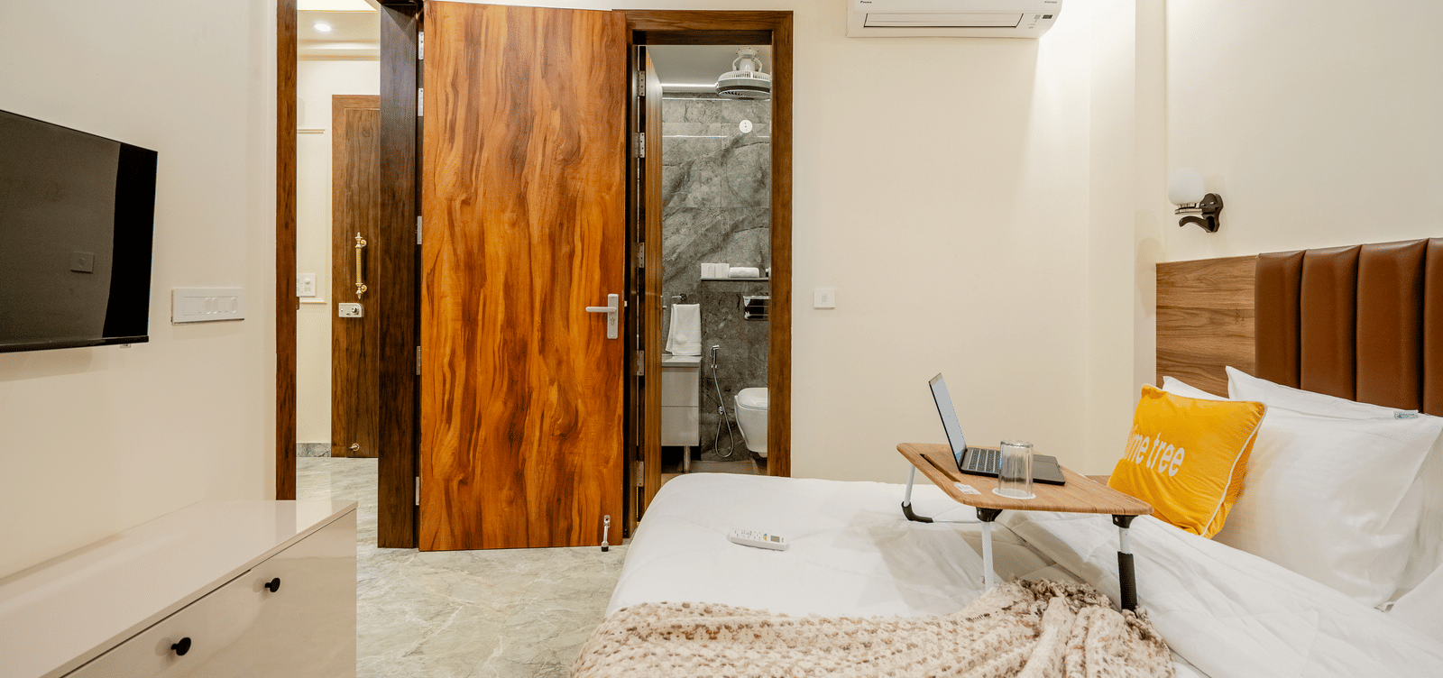 Bedroom with a large bed, wardrobe, and attached bathroom offering modern comfort at Lime Tree 1BHK Service Apartment Near Artemis Hospital Gurgaon.