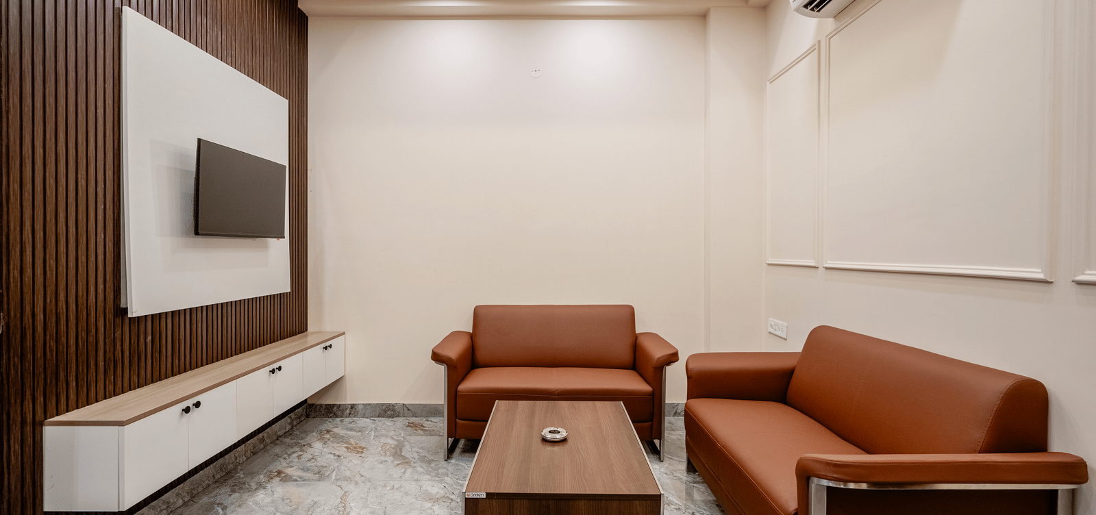 Cosy sitting area with sofas and a centre table in the living room at Lime Tree 1BHK Service Apartment Near Artemis Hospital Gurgaon.