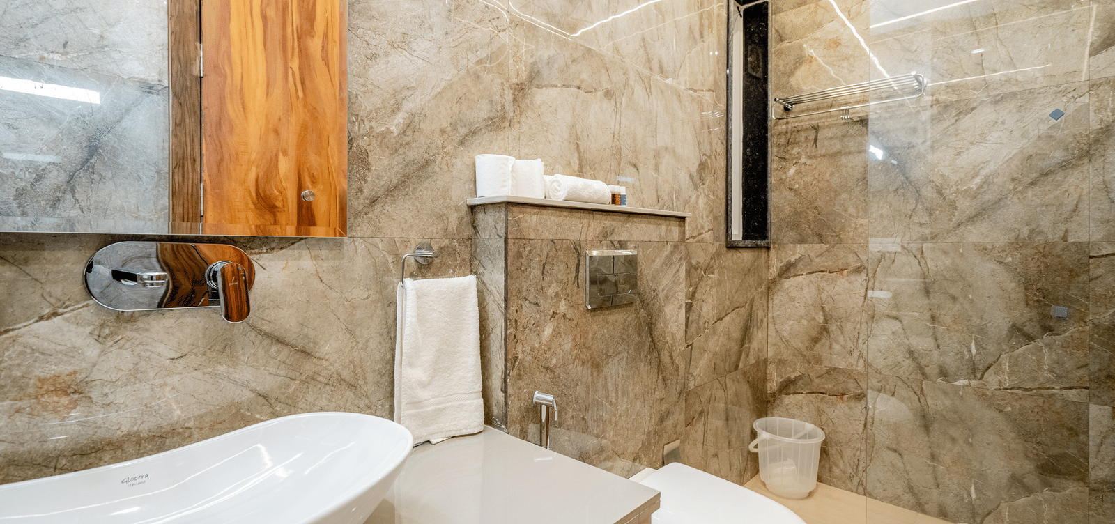Well-designed bathroom with modern fittings and tiled interiors at Lime Tree 1BHK Service Apartment Near Artemis Hospital Gurgaon.