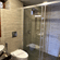  Hotel Devnadi, Haridwar | A bathroom with a toilet seat, a sink, a mirror, and lights.