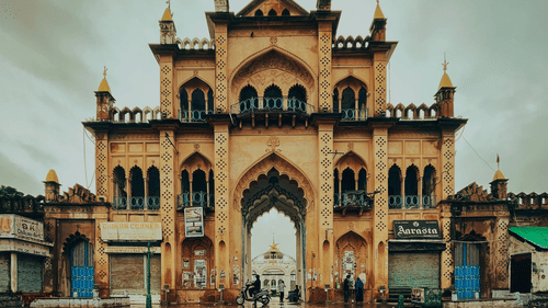 Wide view of a ancient gate with its reflection in the water on the road