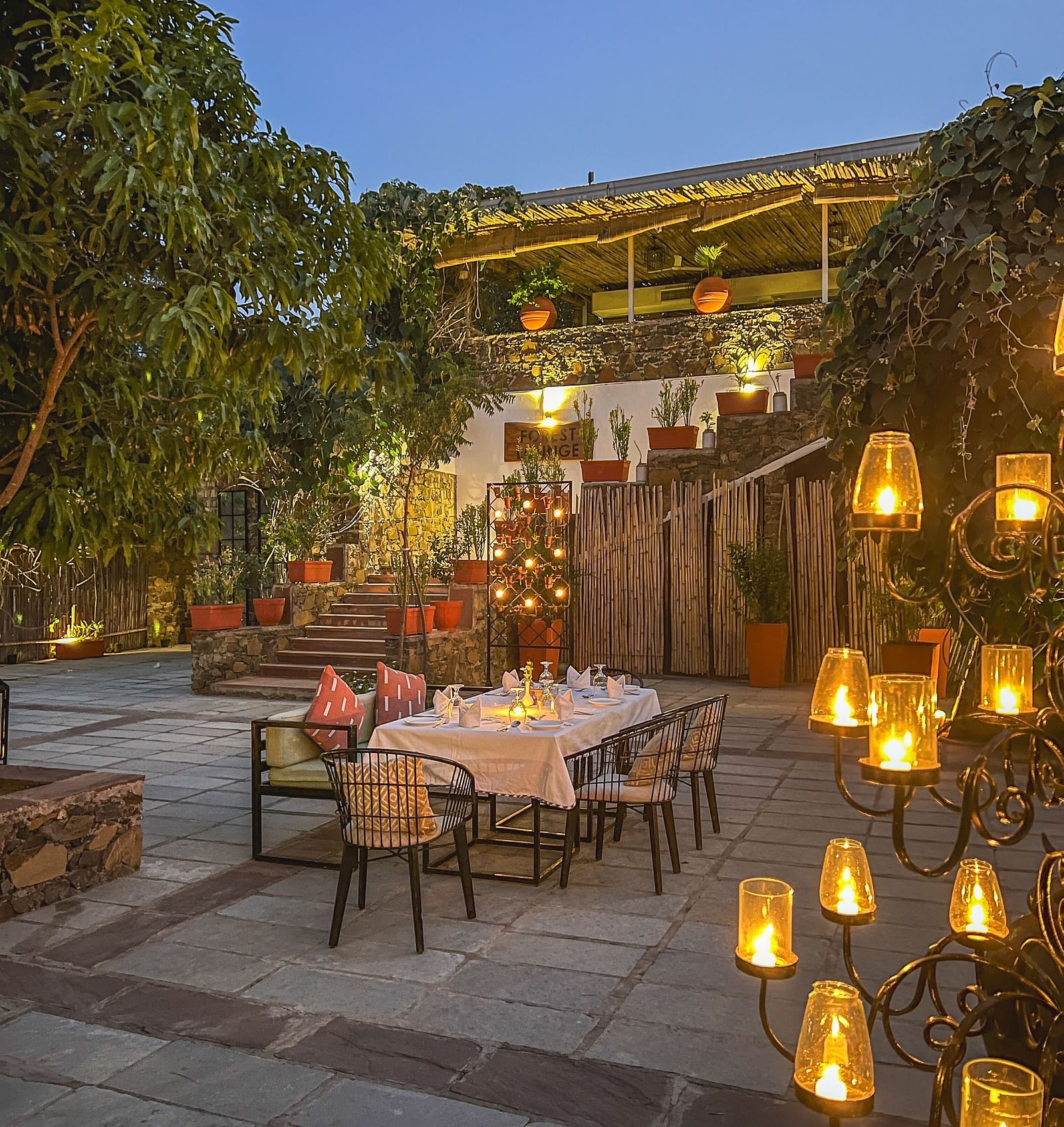 An image of an outdoor dining area with bright decorative lighting - Utsav Camp Sariska