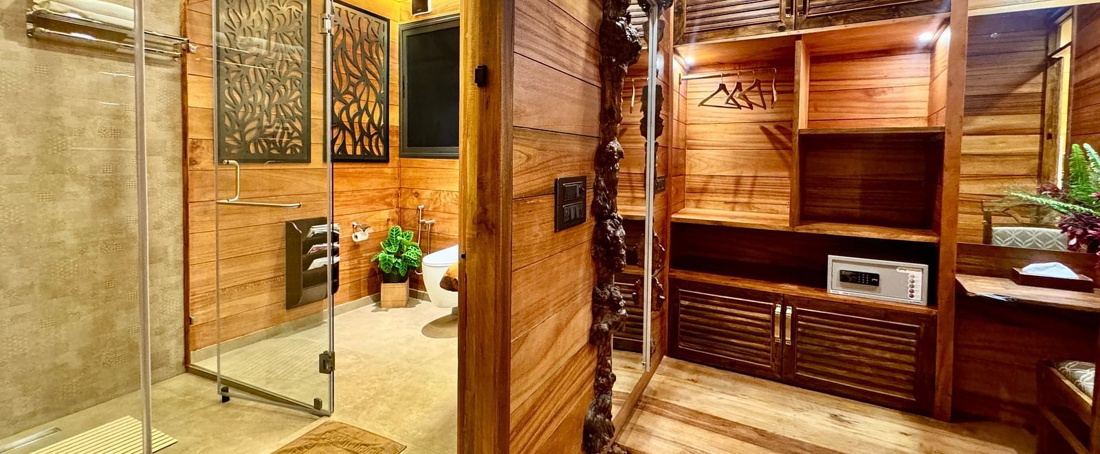 Warmly lit interior of a wooden tree house showing a bathroom area with wooden cabinets and decor - BluSalzz Collection - Tranquil Resort, Wayanad