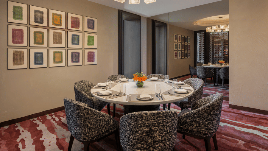 Executive Lounge with a round dining table, framed art wall and chandelier at The Residency Signature Madurai.