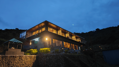 A night view of the facade of the resort with blue sky in the background | Ibex Stays and Trails