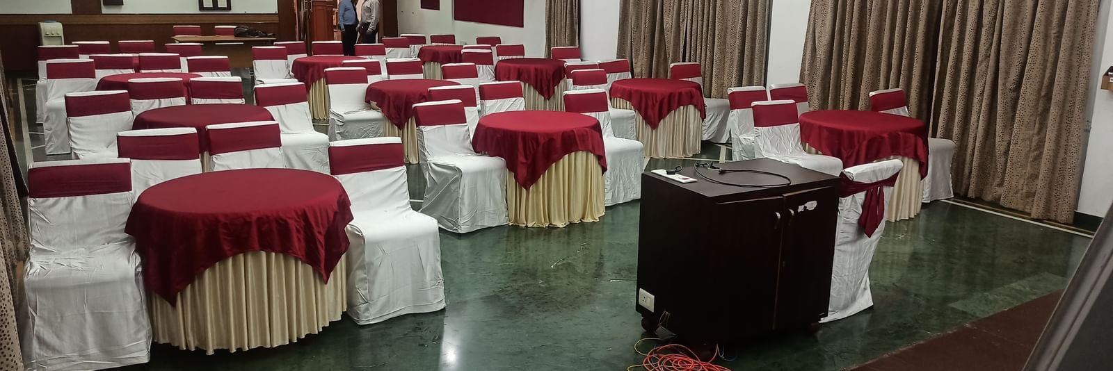 Event hall at Mayur Retreat with round tables dressed in elegant linens, perfect for weddings and formal occasions.
