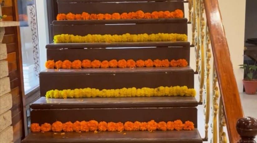 image of the staircase going up decorated with orange and yellow flowers at the tambulam at hoysala village resort in hassan