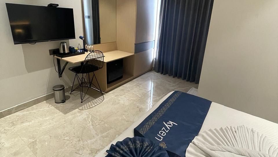 Suite with stylish furniture, including a sofa and writing desk at Hotel Kyzen HiTech City – Your Zenly Stay