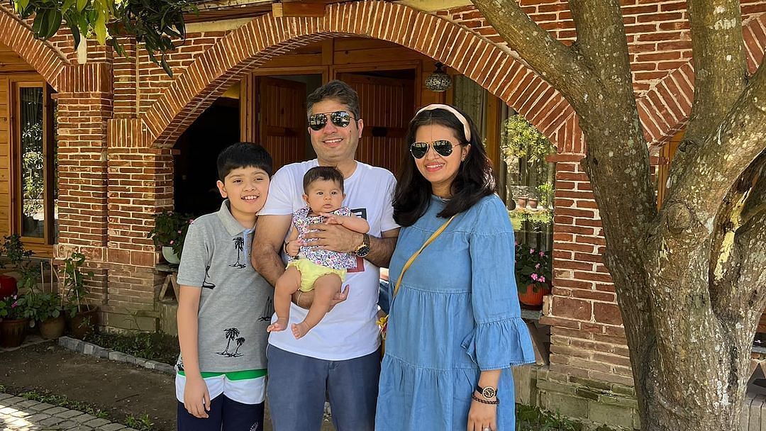 A family standing under a shaded tree at The Sylvan Retreat, Dehradun.