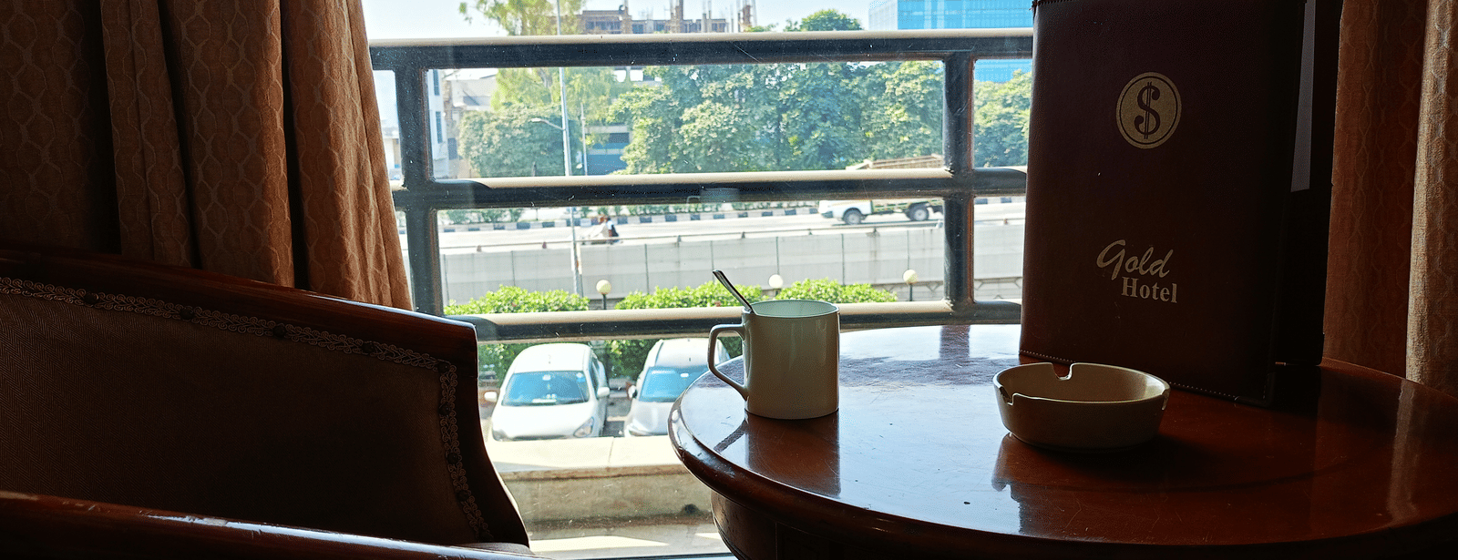 Balcony view at Hotel Gold, Panipat showing outdoor seating and the surrounding area visible through the railing.