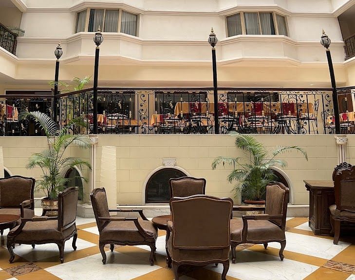 Interior of Nalapad's Hotel Bangalore International featuring a multi-story lobby with seating areas.