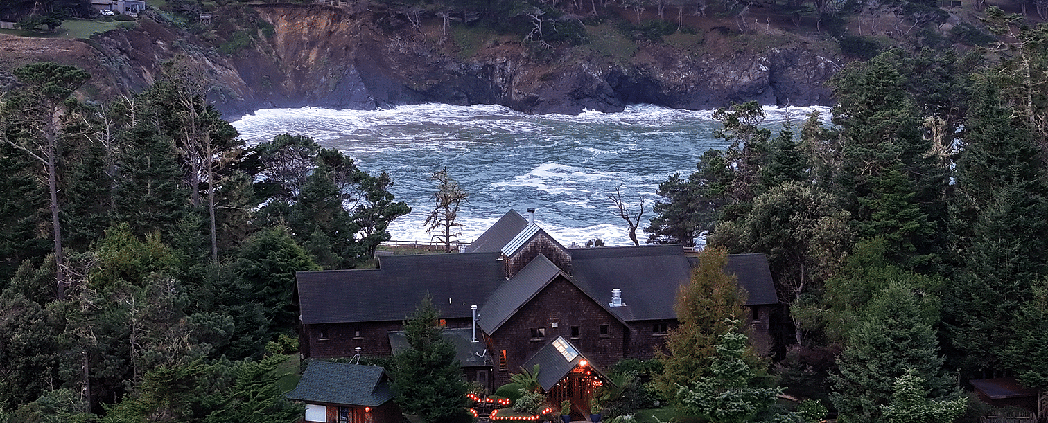 Waves of Mendocino coast crashing against the shore situated behind a hotel - Brewery Gulch Inn & Spa