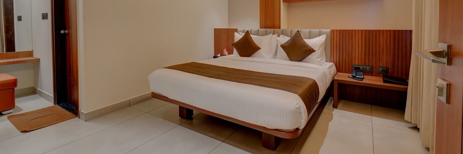 An image of a room at Hari Govindas, Siddappa Square, featuring a bed with a door on the side.