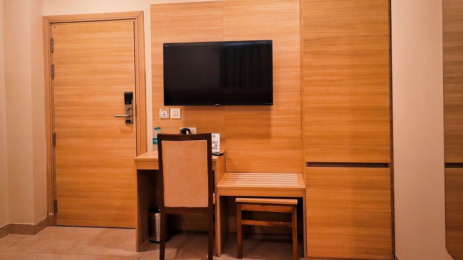 Image of a tablewith a chair and a television mounted on the wall at Clarks Inn Express, Udaipur.