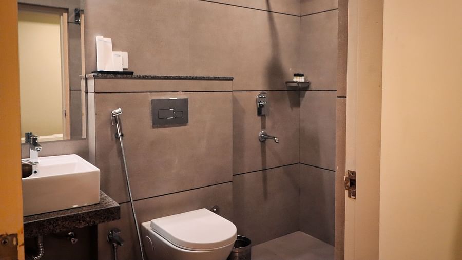 Image of the washroom of Super Deluxe Room with a sink and toilet at Clarks Inn Express, Udaipur.