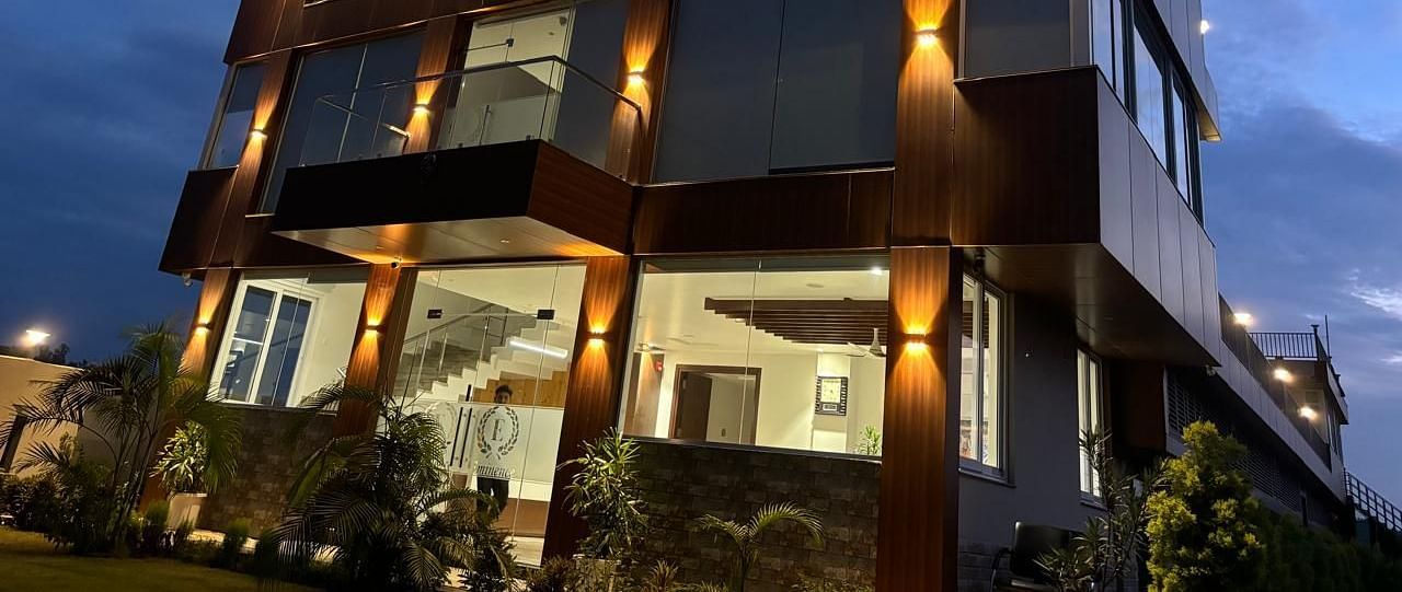 close up image of the facade of Eminence The Corbett with exterior lighting and beautiful evening sky in the background