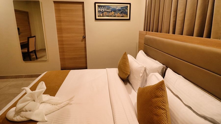 Side view of Super Deluxe Room with a bed and a photo frame on the wall at Clarks Inn Express, Udaipur.