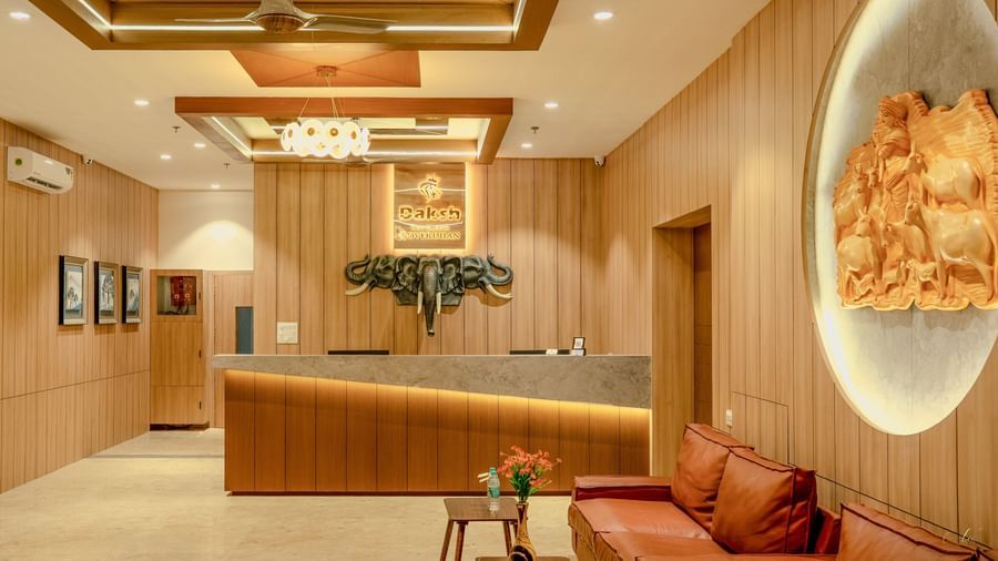 Reception area of Daksh The Grand Gowardhan, Dwarka, with a sleek desk, seating, and ambient lighting.