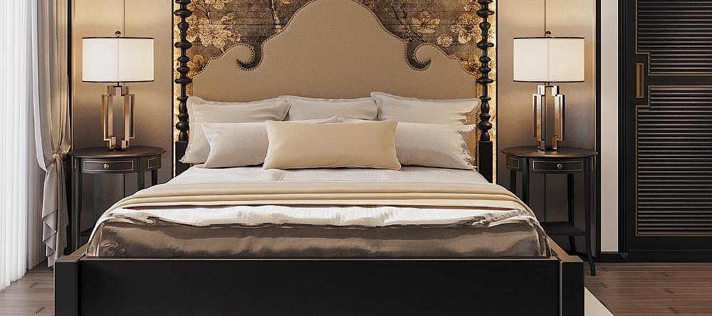 Front view of a well-made bed with cushions, a ceiling fan, and two bedside tables with lamps at The Evren, Vagator.