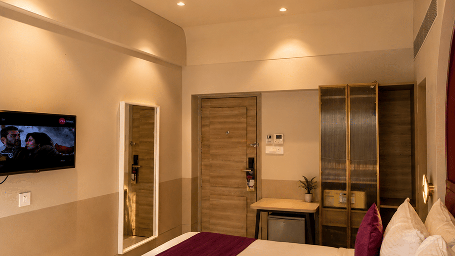 The Oriental Residency | A room with a large bed, spreads, pillows, and a television.