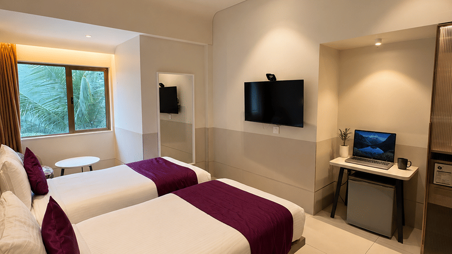 The Oriental Residency | A room with twin beds, spreads, pillows, and a television.