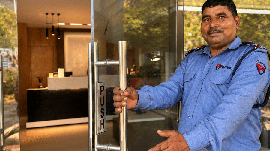 A watchman opening the door in the entrance | The Pamposh, New Delhi