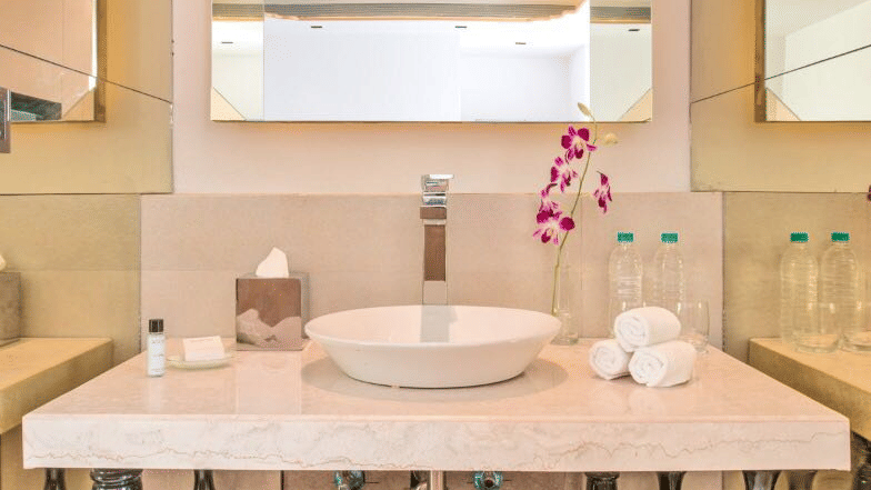 White bathroom sink with white towels and toiletries placed beneath