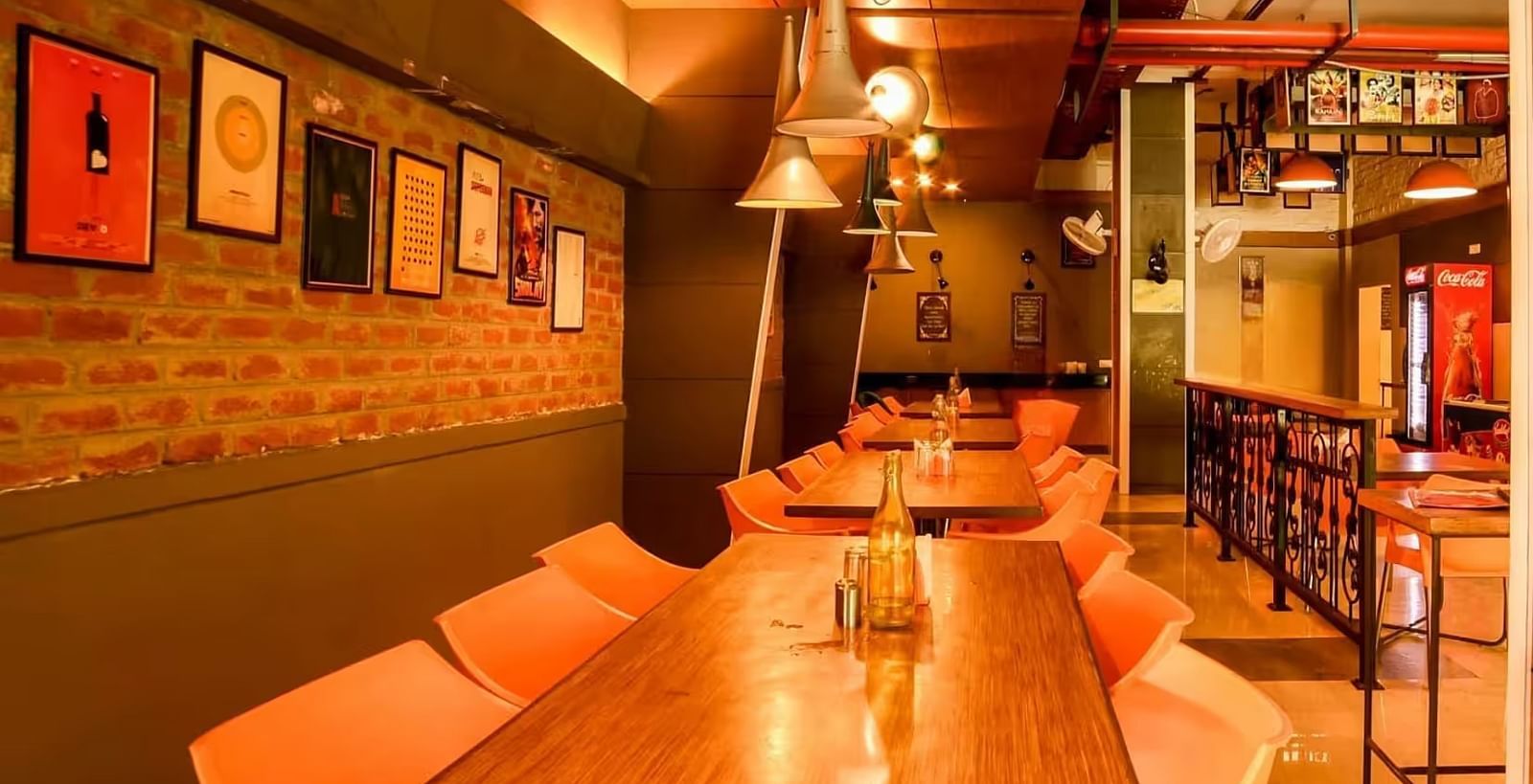 View of Mumbai Masala Restaurant with a warm ambience, wooden table and chairs, and stylish lighting- Max Hotel Prayagraj.