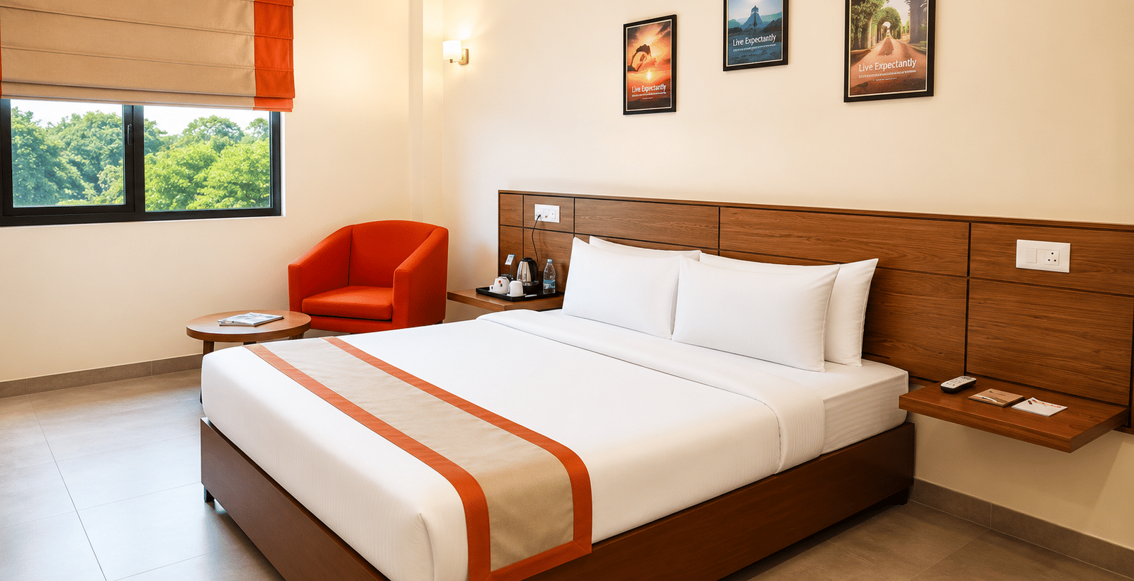 Max Queen Room at Max Hotel Jabalpur featuring a queen size bed, bedside tables and large windows with natural light.