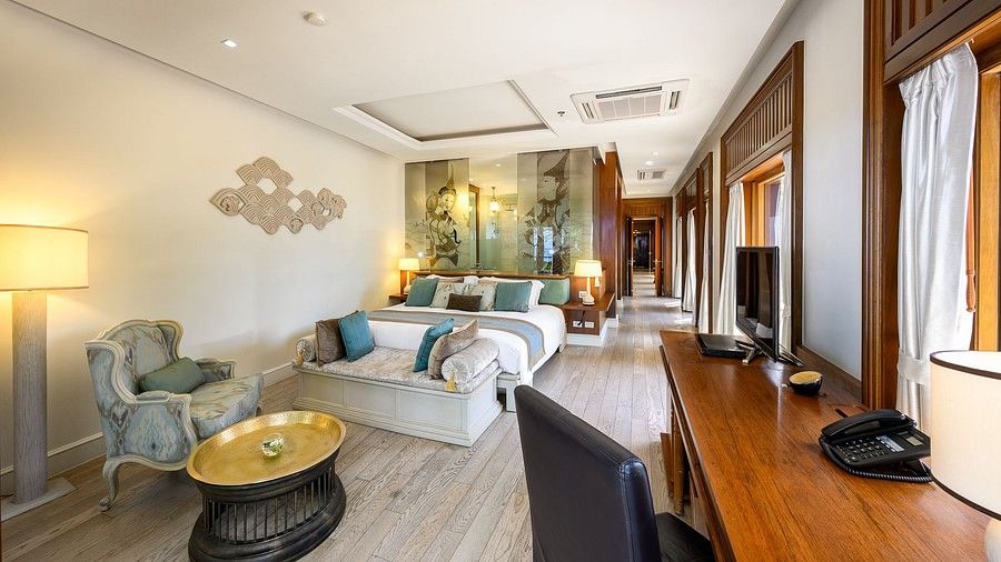 front view of a luxurious bedroom featuring a common seating area in front of the bed - one bedroom private pool beachfront villa