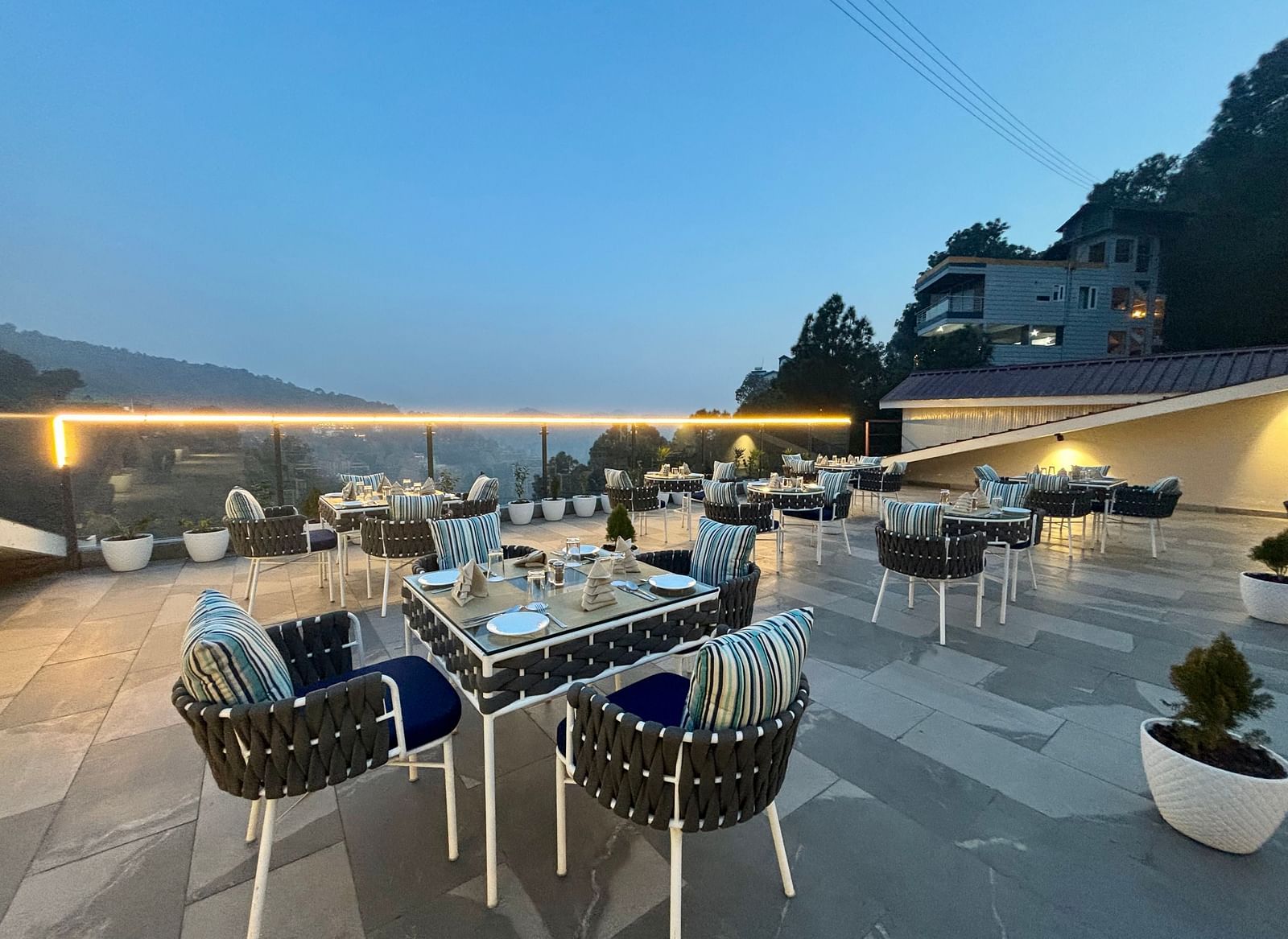 Outdoor dining area at twilight with neatly arranged tables and scenic views – ARNISA Boutique Hotel