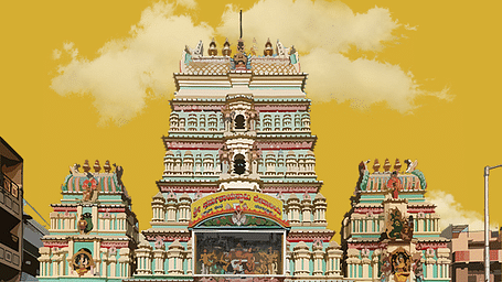 A multi-tiered temple with a yellow sky, showcasing detailed carvings.